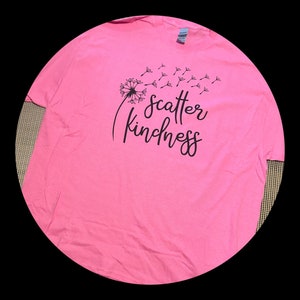 May include: Pink t-shirt with a black dandelion graphic and the text "Scatter Kindness".
