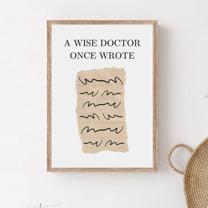 May include: A framed print with the text "A wise doctor once wrote" and a drawing of a crumpled piece of paper with lines on it.