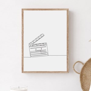 Puede incluir: Un dibujo en blanco y negro de una claqueta en un marco de madera. La claqueta está abierta y el dibujo es minimalista.