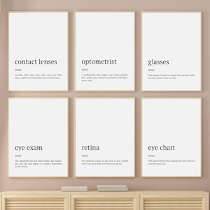 Könnte beinhalten: Sechs gerahmte Kunstdrucke mit weißen Hintergründen und schwarzem Text. Die Drucke zeigen Wörter, die sich auf die Augenpflege beziehen: "Kontaktlinsen", "Optometrist", "Brille", "Augenuntersuchung", "Netzhaut" und "Sehtafel". Jeder Druck enthält eine Definition.