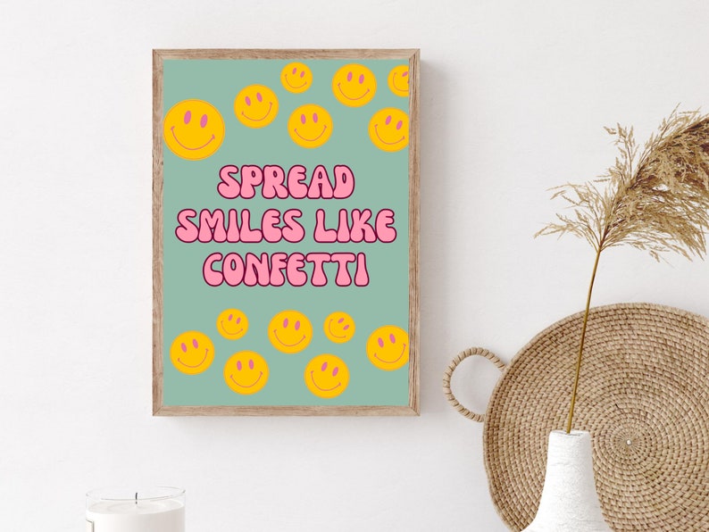 May include: A light blue poster with the text "SPREAD SMILES LIKE CONFETTI" in pink bubble letters. The poster is decorated with yellow smiley faces.