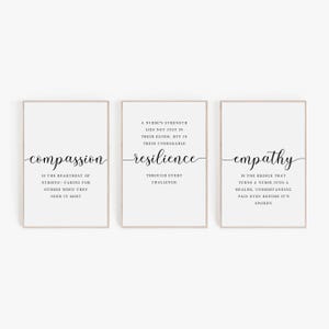 May include: Three framed prints with inspirational quotes about nursing. The first print says "compassion" with the text "is the heartbeat of nursing - caring for others when they need it most." The second print says "resilience" with the text "a nurse's strength lies not just in their hands, but in their unshakable through every challenge." The third print says "empathy" with the text "is the bridge that turns a nurse into a healer, understanding pain even before it's spoken."