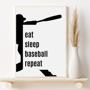 May include: Black and white silhouette of a baseball player swinging a bat with the text "eat sleep baseball repeat" on a white background.