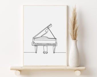 May include: A black and white line drawing of a grand piano, printed on a white background and framed in a simple wooden frame. The print is displayed on a shelf with a vase of dried pampas grass.