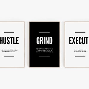 May include: Three framed motivational posters with the words "HUSTLE", "GRIND", and "EXECUTE" in bold black font. Each poster has a minimalist design with a white background and a thin black line above and below the text. The "GRIND" poster has a black background.