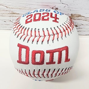 May include: White baseball with red stitching and red embroidered text "Class of 2024" and "Dom"