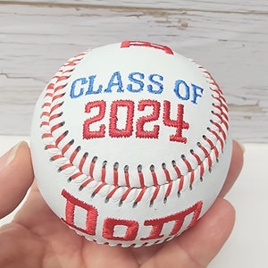 May include: White baseball with red stitching and red embroidered text that says "Class of 2024" and "DOTT"