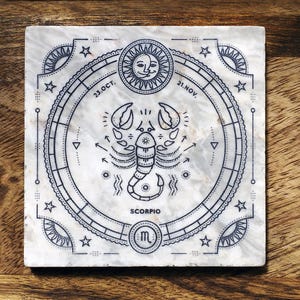 Könnte beinhalten: Quadratischer Marmoruntersetzer mit detailliertem schwarz-weißem Skorpion-Tierkreiszeichen-Design. Das Design umfasst eine Sonne mit Gesicht, Sterne und die Daten 23.OCT. und 21.NOV. Das Wort "SCORPIO" ist ebenfalls enthalten.
