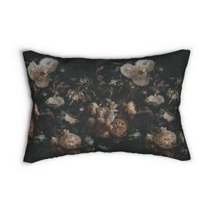 May include: Rectangular decorative pillow with a dark background and a floral pattern. The design features cream and peach-colored roses and other flowers, with dark green foliage. The pillow has a soft, textured appearance.