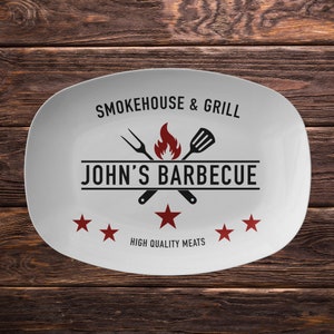 May include: White oval serving platter with black text that reads "Smokehouse & Grill" and "John's Barbecue" with a red flame and crossed grilling utensils. The text "High Quality Meats" is below the logo and there are five red stars.