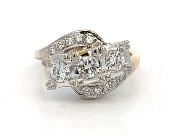 May include: A gold and white diamond ring with three round diamonds set in a twisted band.