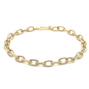 May include: A gold chain bracelet with a twisted oval link design.