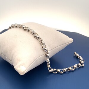 May include: A silver bracelet with a chain made of small, round beads.