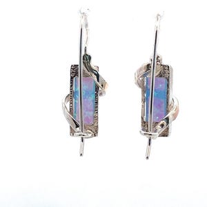 May include: A pair of silver earrings with a rectangular opal stone set in a twisted silver design.