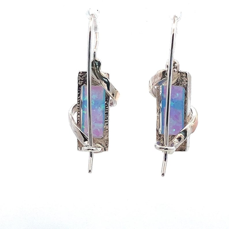 May include: A pair of silver earrings with a rectangular opal stone set in a twisted silver design.