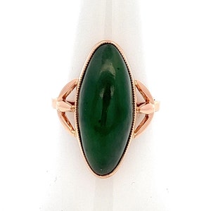 May include: A vintage ring with a large oval green gemstone set in a gold setting. The ring has a delicate design with intricate details.