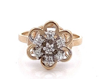 May include: A gold ring with a flower-shaped design set with small diamonds.