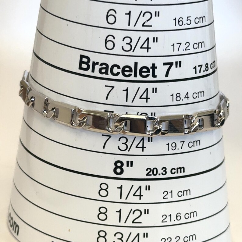 May include: A silver bracelet with rectangular links is displayed on a bracelet sizing cone. The cone shows measurements in inches and centimeters, with the bracelet appearing to be approximately 7 inches (17.8 cm) in length.