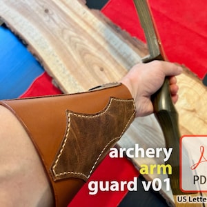 Op de afbeelding: Een bruine leren boogschieten arm beschermer met een suède patch en stiksels. De beschermer wordt gedragen op de linkerarm van een persoon die een boog vasthoudt. De tekst "archery arm guard v01" is zichtbaar in de afbeelding. De afbeelding bevat ook een PDF-pictogram met de tekst "US Letter & A4" eronder.