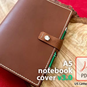 May include: Brown leather notebook cover with white stitching and a suede closure. The cover is designed for A5 notebooks and includes the text "A5 notebook cover v3.0" and a PDF icon with the text "PDF".