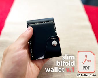 May include: A black leather slim bifold wallet with white stitching and a silver snap closure. The wallet is being held in a hand. The text "slim bifold wallet v.1" and "PDF" are visible in the image.