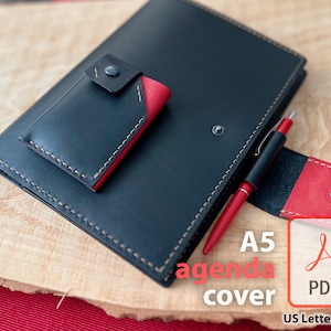 May include: A black leather A5 agenda cover with a red leather pocket and pen holder. The cover has a stitched edge and a red leather flap with a button closure. The text "A5 agenda cover" and "PDF" are printed on the image.