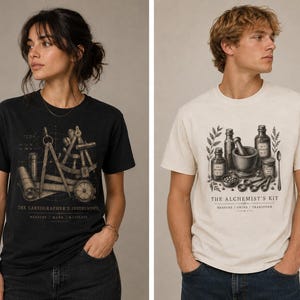 May include: Two t-shirts, one black and one cream-colored, each featuring a detailed graphic. The black shirt displays cartographer's instruments with text. The cream shirt showcases an alchemist's kit with bottles and a mortar and pestle, also with text.