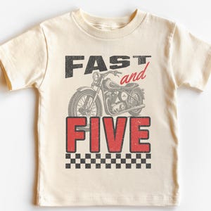 May include: A cream colored t-shirt with a vintage style graphic of a motorcycle and the text "FAST and FIVE" in red and black.