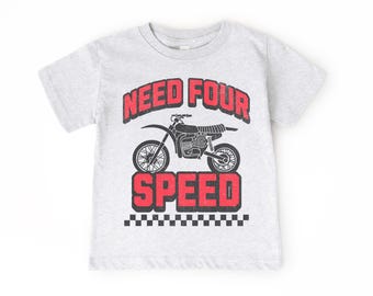 Puede incluir: Camiseta gris con una ilustración en blanco y negro de una moto de cross y el texto "NEED FOUR SPEED" en rojo.