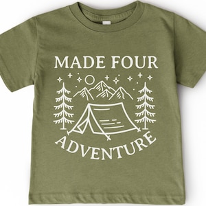 Peut inclure: T-shirt vert olive avec l'inscription blanche "MADE FOUR ADVENTURE". Le motif comprend une tente, des montagnes, des arbres, des étoiles et une lune. Le t-shirt à manches courtes est adapté aux enfants.