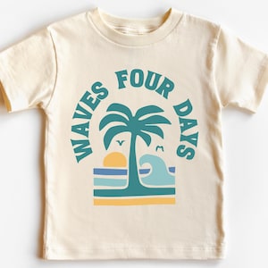 May include: Cream-colored t-shirt featuring a beach-themed graphic. The design includes a palm tree, sun, waves, and the text "WAVES FOUR DAYS" in teal. A casual, short-sleeved tee for kids.