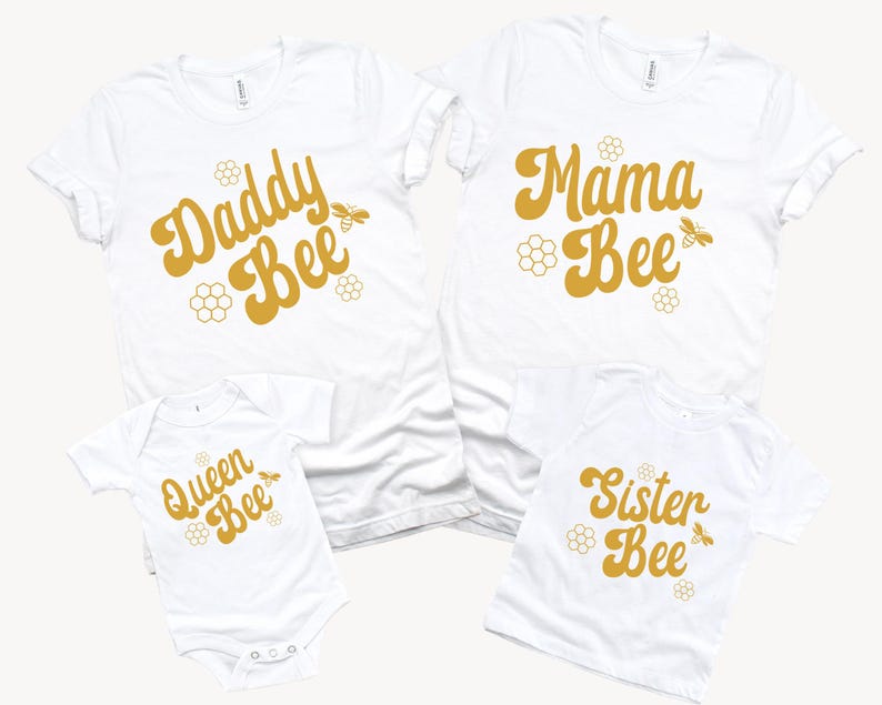May include: A set of four white t-shirts with a bee theme. The shirts feature the text "Daddy Bee", "Mama Bee", "Queen Bee", and "Sister Bee" in a retro font with a bee illustration.
