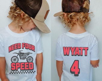 Puede incluir: Camiseta blanca con un gráfico de una moto de cross en blanco y negro y el texto "Need Four Speed". La parte posterior de la camiseta tiene el nombre "Wyatt" y el número "4" en rojo.