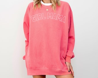 May include: A pink sweatshirt with the text "GIRL MAMA" in white outlined letters.