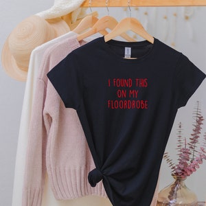 Puede incluir: Camiseta negra con texto rojo que dice "I found this on my floordrobe".