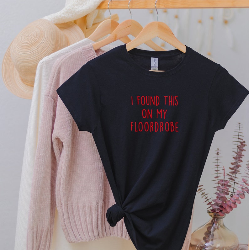 Puede incluir: Camiseta negra con texto rojo que dice "I found this on my floordrobe".