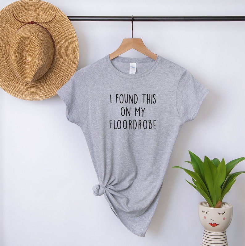Puede incluir: Camiseta gris con el texto "I found this on my floordrobe" impreso en negro.