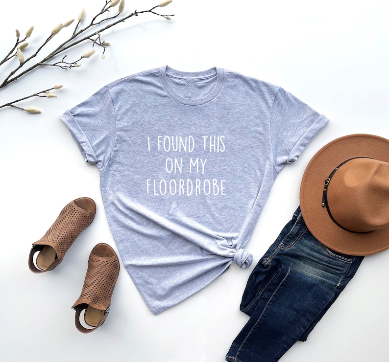 Puede incluir: Una camiseta gris con el texto "I found this on my floordrobe" impreso en blanco.