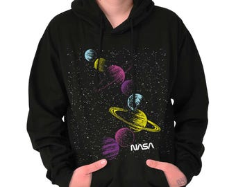 May include: Black hooded sweatshirt featuring a colorful graphic of planets in space, with the word "NASA" in white. The planets are in shades of yellow, purple, blue, and pink against a starry background.