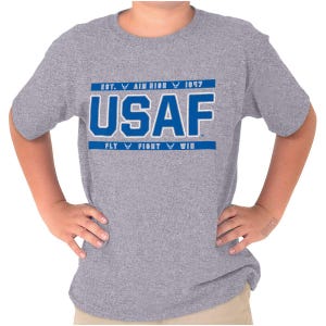 May include: A gray t-shirt featuring the text "USAF" in bold blue letters with a white outline. Above the text are the words "EST. AIM HIGH 1947" and below it reads "FLY FIGHT WIN", all in blue. The shirt is short-sleeved.