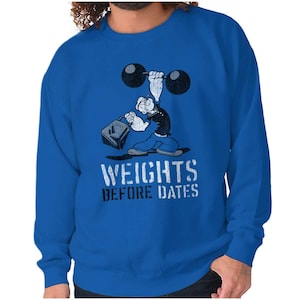 May include: A blue sweatshirt with a cartoon sailor lifting weights. The text "WEIGHTS BEFORE DATES" is printed on the front of the sweatshirt.