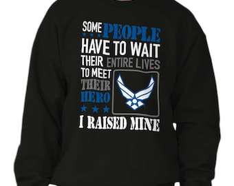 May include: Black sweatshirt with a white graphic that reads "Some people have to wait their entire lives to meet their hero. I raised mine." The graphic also includes a blue Air Force emblem.