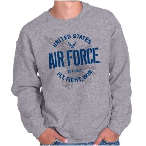 May include: Gray sweatshirt with the text "UNITED STATES AIR FORCE" in blue, along with "EST. 1947" and "FLY. FIGHT. WIN." The design includes an eagle graphic. The sweatshirt is a crew neck style.
