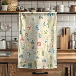 Decorative Mahjong print tea towel styled on a wooden counter with cookware
