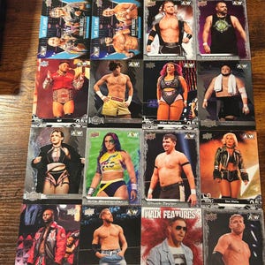 May include: A collection of AEW wrestling trading cards. Each card features a wrestler with their name and the AEW logo. The cards are on a wooden surface.