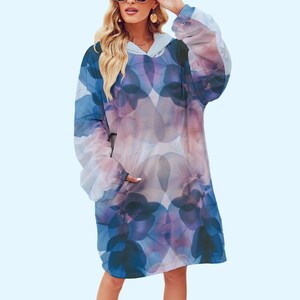 Pode incluir: Um cobertor com capuz em tons de azul, roxo e rosa, com um padrão floral. O cobertor vestível oversized tem um bolso frontal e mangas compridas. O design macio e aconchegante é perfeito para relaxar.
