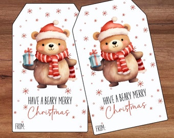 May include: Two white gift tags with a cartoon bear wearing a red Santa hat and scarf holding a blue gift box. The text on the tags reads "Have a Beary Merry Christmas".