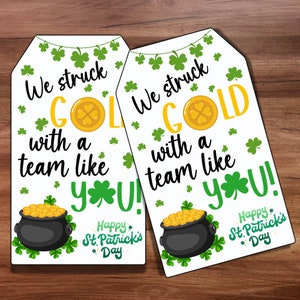 May include: Two white gift tags with green shamrocks and gold coins. The text on the tags reads "We struck GOLD with a team like YOU! Happy St. Patrick's Day".