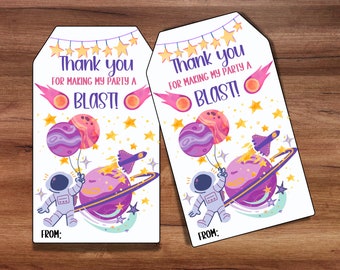 May include: Two white thank you tags with a space theme. The tags feature an astronaut holding a purple planet balloon, a rocket ship, and stars. The text on the tags reads "Thank you for making my party a blast!"