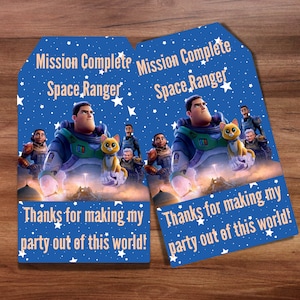 Può includere: Due tag di ringraziamento blu e bianchi con un tema di ranger spaziale. I tag mostrano un ranger spaziale dei cartoni animati e un gatto. Il testo sui tag recita "Missione Completata Ranger Spaziale" e "Grazie per aver reso la mia festa fuori dal mondo!"